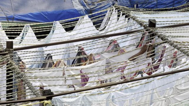 Mumbai, Maharashtra, India &ndash; January 25 2026: Workers twisting wet clothes into ropes for drying at Dhobi Ghat.