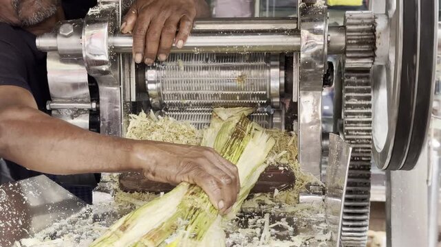 Mumbai, India - January 27, 2026. Street vendor operating a traditional sugar cane juice press at a local market. Real street food preparation and small business activity. Editorial use only.