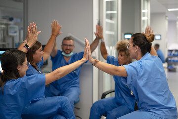 Obraz premium Medical team high fiving showing teamwork and success