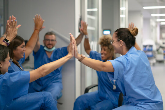 Medical team collaborating and celebrating success with high five