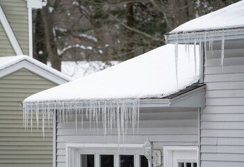 winter house with icicle and snow on the roof