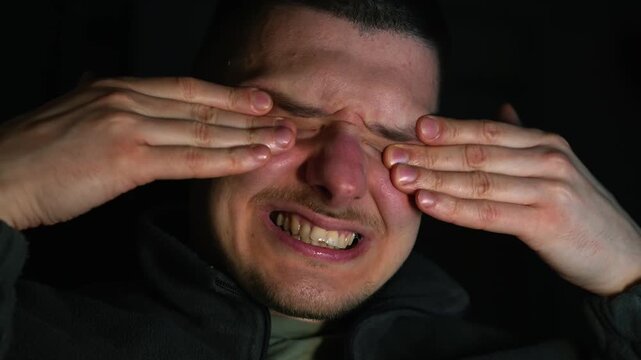 A man rubs his eyes with his hands.
Something got into the guy's eye.
Eye discomfort.
Sore eyeball.