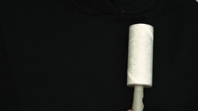Removing lint and lint from dirty clothes with a lint roller.
Dust and dirt removal from clothes