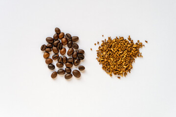 Comparison coffee beans and instant coffee granules on a white background. Choice concept. Top view closeup.