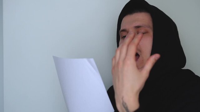 A young actor holding a paper script.
Casting for a role.
An artistic man reads the script in front of the camera.