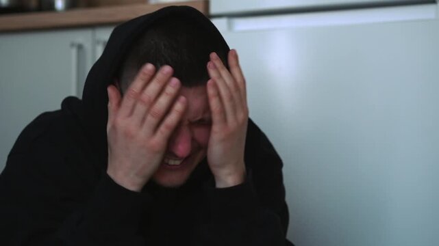 A depressive disorder in a man sitting on the floor.
A man on the floor suffers and cries.
A moody man on the floor is tormented by sad memories.