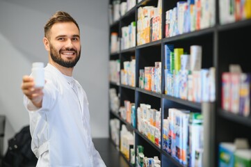 Pharmacist holding medicine bottle in pharmacy