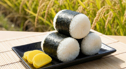 黄金色の稲穂を背景にした手作りの俵むすび