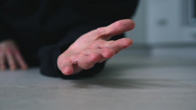 A man lies on the floor in pain.
A man lies in pain on the floor.