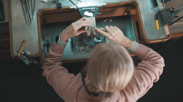 Jeweler crafting a silver ring at a workbench
