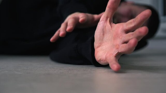 A man lies on the floor in pain.
A man lies in pain on the floor.