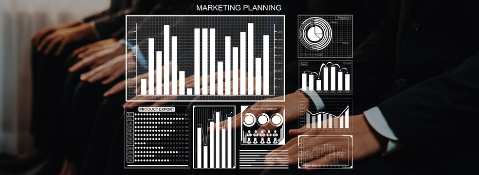 A group of business professionals actively participating in a marketing planning session, featuring digital graphs and charts that illustrate key data analysis and strategies for growth. Axiom - Powered by Adobe