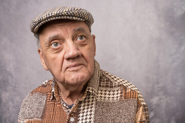 Portrait homme &acirc;g&eacute; Ave b&eacute;ret sur fond gris