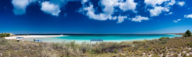 Wide panoramic view of Coral Bay beach showcasing coastline and crystal clear sea