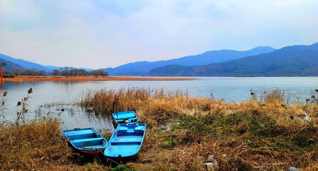 Peaceful landscape of the Han River with traditional wooden boats anchored on the shore in South Korea. © 바움