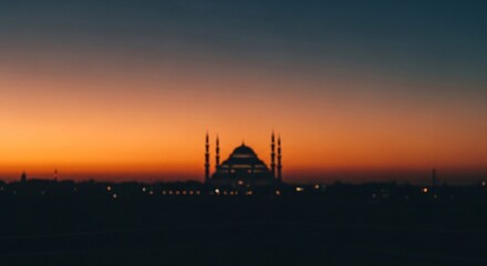 Naklejka premium Mosque silhouette at sunset with vibrant sky