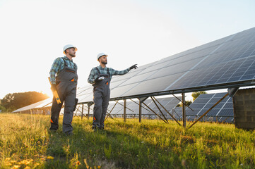 Engineers inspecting solar panels on power field