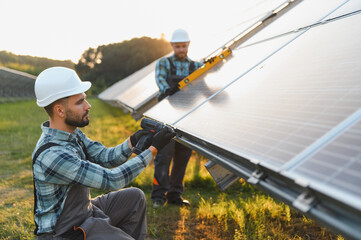 Naklejka premium Workers installing solar panels for renewable energy