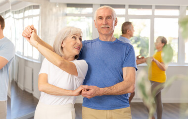 Obraz premium Elderly man and elderly woman dance ballroom dance waltz in studio