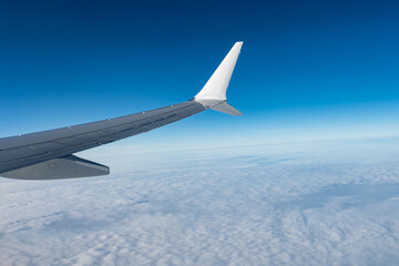 Fototapeta premium Airplane wings extend above white clouds, providing clear view of atmospheric layers and sense of altitude during the flight, air transportation