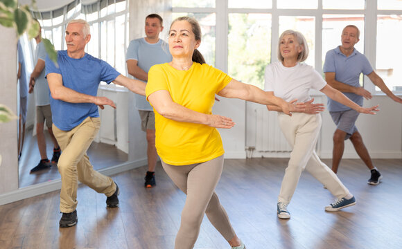 Cheerful elderly woman attending group choreography class, learning modern dynamic dances. Concept of active lifestyle of older generation..