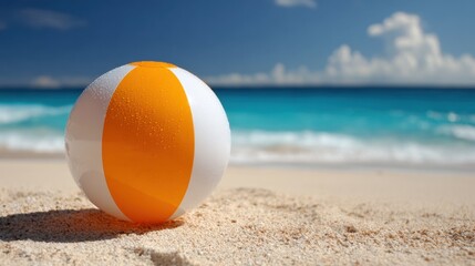 Obraz premium Vibrant beach ball on sandy shore with ocean waves in background.