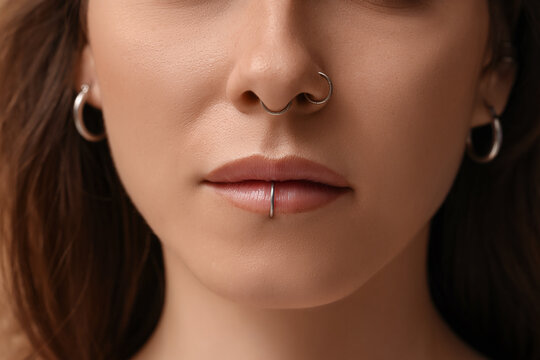 Pretty young woman with nose and lip piercing, closeup