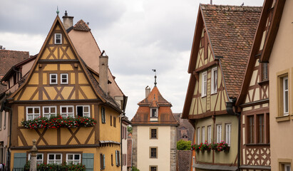 Obraz premium Plönlein little square with Siebersturm tower, half‑timbered houses, cobblestone streets, fountain and shops in historic Rothenburg ob der Tauber, Bavaria, Germany travel landmark.