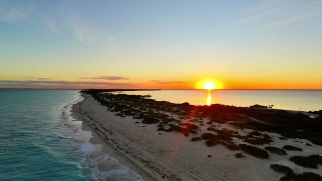 Cinematic 4K aerial drone view of the untouched white sand beaches and turquoise waters of Isla Blanca peninsula in Cancun during the first sunrise of the new year
