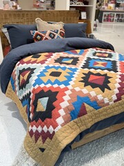 Stylish bedroom interior with colorful patterned bedding, decorative pillows, and woven headboard, cozy modern home decor setup with warm textures and inviting atmosphere.