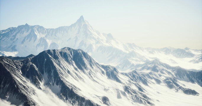 Hazy mountain silhouette at soft sunrise, muted tones and gentle mist soften jagged ridgelines while distant peaks fade into pale sky creating tranquil mood