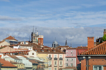 Historic Madrid Cityscape with Terracotta Rooftops and Church Spires under Cloudy Sky