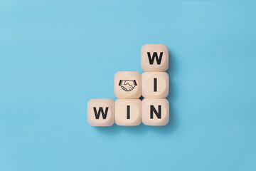 Win win wording with hand shaking icon on wooden cube block. win-win in business concept for success and business deal situation concept. copy space