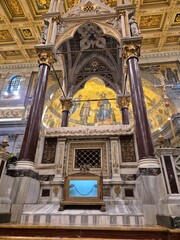 Rome, Italy - 14 January 2025. Main altar of St Paul’s Outside the Walls featuring marble baldachin, relic of St Paul’s chains, red columns, and Christ mosaic in golden apse. © Michael