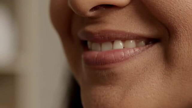 Minimal smirk expression. A calm intimate shot showing a barely noticeable smirk forming on one side of a persons mouth.