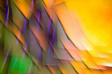 Abstract, blurry and colorful umbrella close-up detail through kaleidoscope glasses lens.