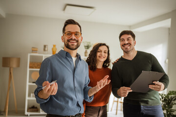 Real estate agent showing potential home to young couple