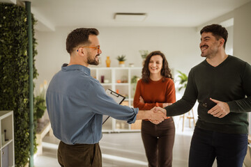Real estate agent shaking hand with new home buyer