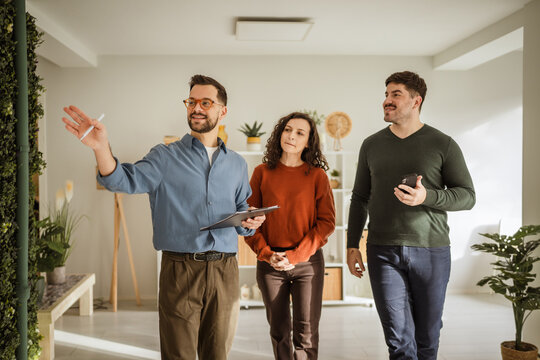 Real estate agent showing potential home to young couple