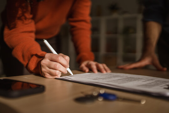 Person signing legal contract for real estate deal