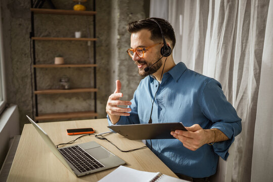 Man wearing headset making video call from home office