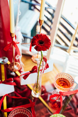 Decorative Valentines day setup featuring red flowers candles and glassware on a table during a gathering