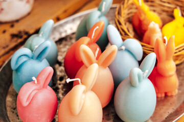 Bunnies made of wax in various colors sit on a tray alongside other decorative items