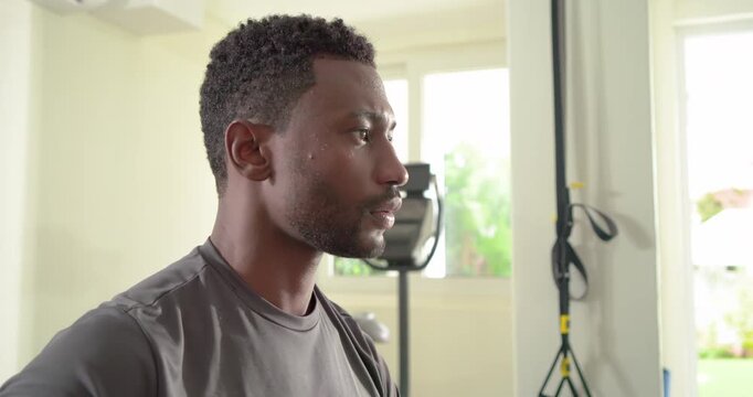 African American man closing eyes breathing deeply regaining focus after rowing in gym, copy space