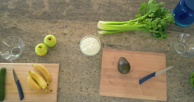 Camera is panning right, bringing avocado cutting board into center for food prep