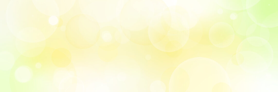 明るいグリーンとイエローの抽象背景｜やさしい光とバブル・玉ボケのベクター 横長