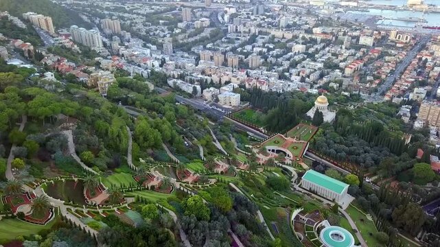 Aerial cinematic view of the Bah&aacute;'&iacute; Terraces and the Golden Dome Shrine on Mount Carmel, Haifa city skyline and harbor background&mdash;Israel