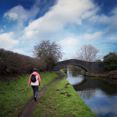 Woman walking along a canal towpath in Winter