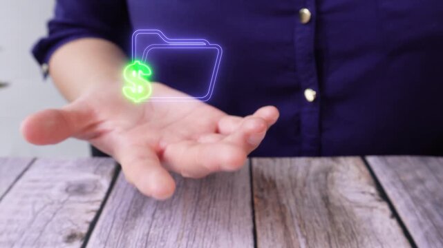 Financial file management. Close-up of a woman's hand on a table holding a virtual icon of a folder with a money symbol.