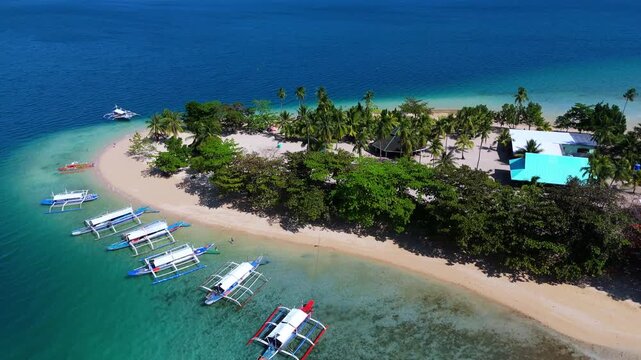 Aerial view of  Cowrie island, Philippines travel destination in Palawan , Puerto princesa . Drone above tropical paradise with sandy coral reef beach and fisherman boat 